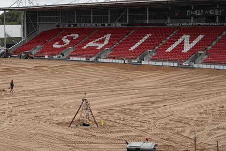 man with shovel on sand filled pitch
