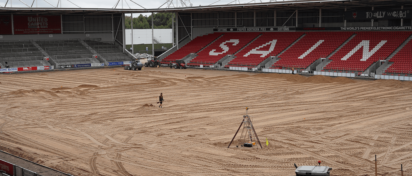 man with shovel on sand filled pitch