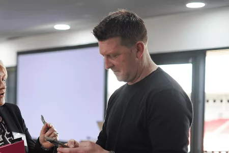 man with phone in hand and woman speaking