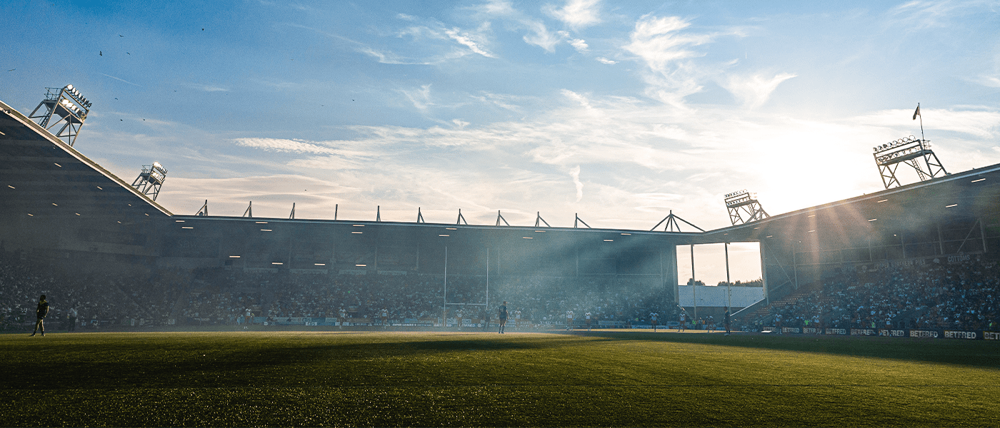 rugby match with sun peering over stands