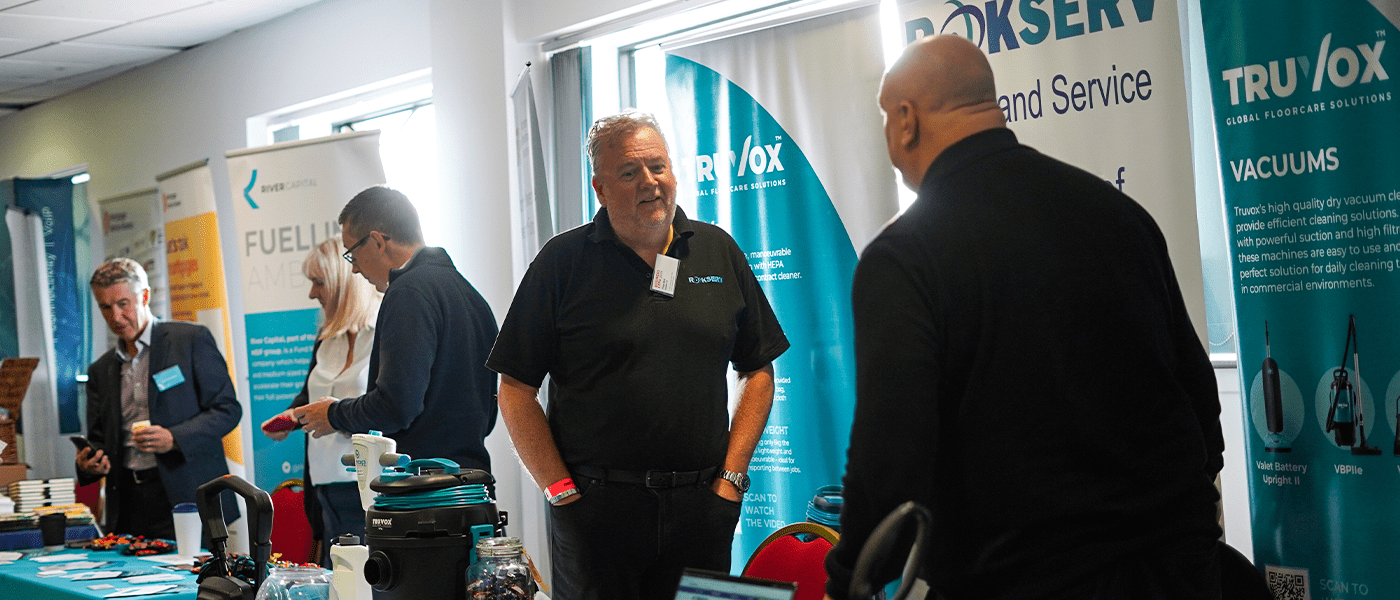 two men speaking to each other at an expo