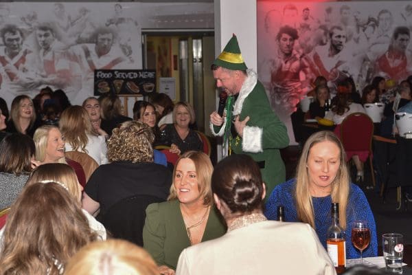 man dressed as elf speaking into microphone