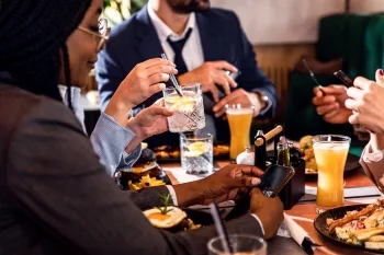 Hands of business people sitting in a restaurant at a business lunch.